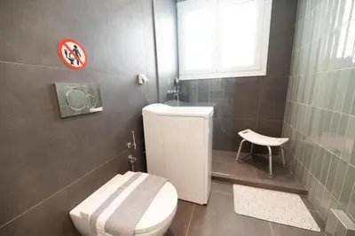 a bathroom with a white toilet and a window at 5th floor Apt with Acropolis view in Pangrati in Athens