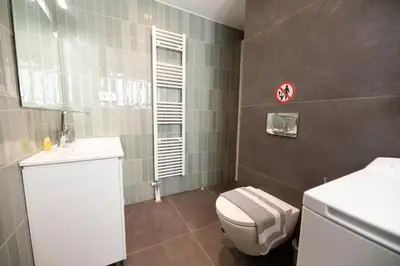 a bathroom with a white toilet and a sink at 5th floor Apt with Acropolis view in Pangrati in Athens