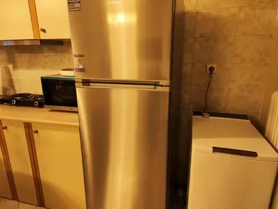 a stainless steel refrigerator in a kitchen next to a microwave at Cozy & Connected in Athens