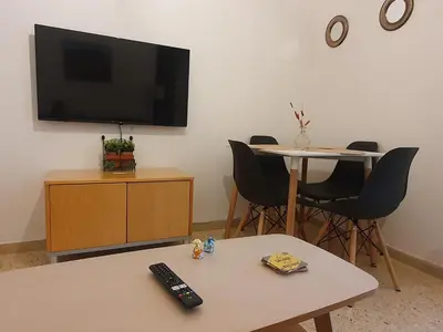 a living room with a television and a table and chairs at Vintage Chic in Athens