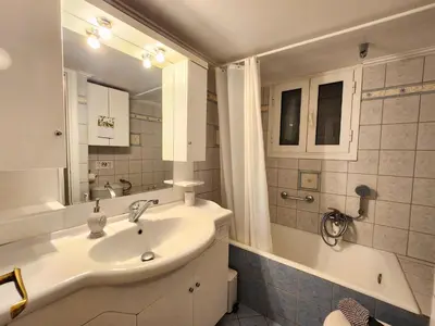 a bathroom with a sink and a tub and a mirror at Vintage Chic in Athens