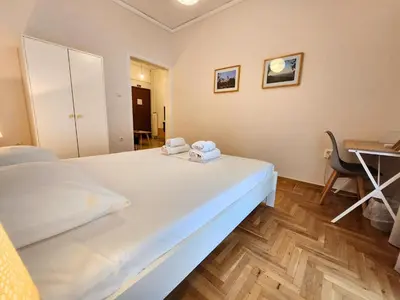 a white bed in a room with a desk at Vintage Chic in Athens