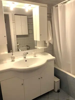 a white bathroom with a sink and a mirror at Vintage Chic in Athens