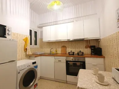 a kitchen with white cabinets and a washer at Vintage Chic in Athens