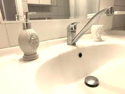 a sink with a faucet and a vase on it at Vintage Chic in Athens