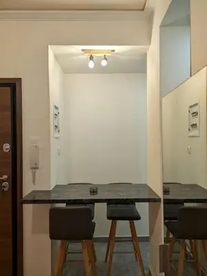 a room with a table with chairs and a mirror at Ασφαλές και σύγχρονο διαμέρισμα in Athens