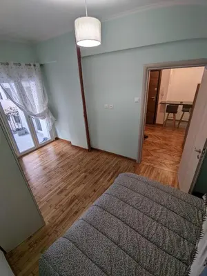 a living room with a bed and a mirror at Ασφαλές και σύγχρονο διαμέρισμα in Athens