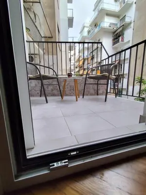 a balcony with two chairs and a table at Ασφαλές και σύγχρονο διαμέρισμα in Athens