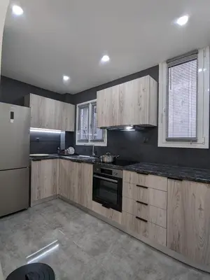 a kitchen with wooden cabinets and a refrigerator at Ασφαλές και σύγχρονο διαμέρισμα in Athens