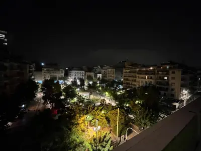 a view of a city at night with lights at MARGARITAS' SUITES viktoria square in Athens