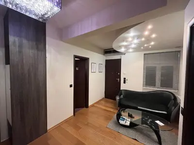 a living room with a black couch and a glass table at MARGARITAS' SUITES viktoria square in Athens