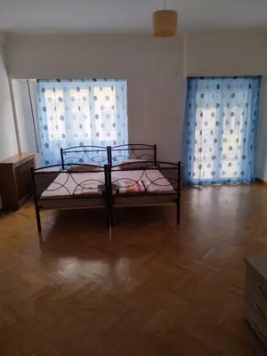 a bed in a room with two windows at Triple room in Athens