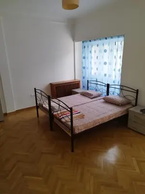 a bedroom with a bed and a wooden floor at Triple room in Athens