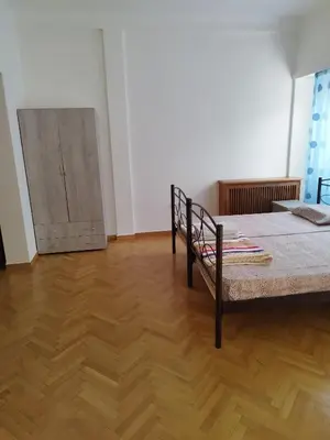 a bedroom with a bed and a wooden floor at Triple room in Athens