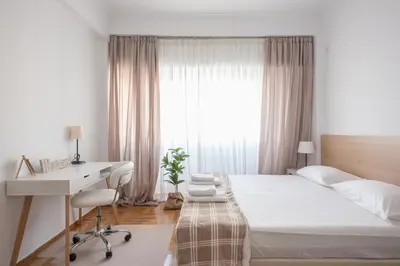 a bedroom with a bed and a desk and a window at Ble Elia Estia Suite in Athens