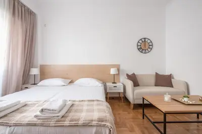 a white bedroom with a bed and a couch at Ble Elia Estia Suite in Athens
