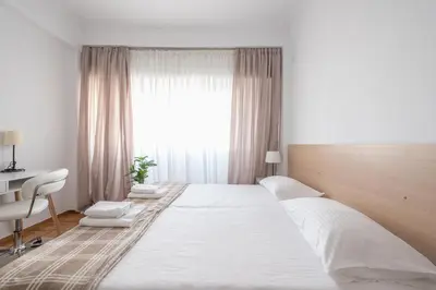 a large white bed in a room with a window at Ble Elia Estia Suite in Athens