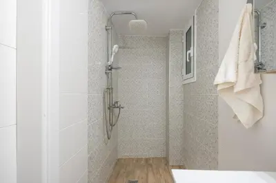 a shower stall in a bathroom with white tiles at Ble Elia Parthenon Suite in Athens