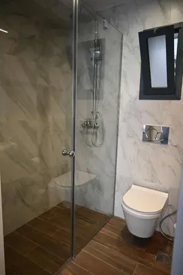 a bathroom with a glass shower with a toilet at Athenian Stay 303 Apartment in Athens