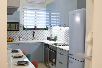 a kitchen with a refrigerator and a table with chairs at Cozy & Luxurious 70m2 apartment in Athens
