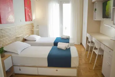 two beds in a hotel room with towels on them at Cozy & Luxurious 70m2 apartment in Athens