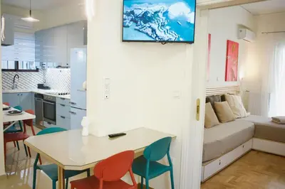 a kitchen and a living room with a table and chairs at Cozy & Luxurious 70m2 apartment in Athens
