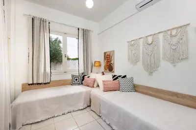 a white room with two beds and a window at Mira Seaside Residence in Kalívia Thorikoú