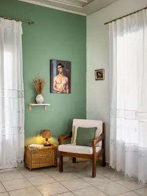 a room with a chair and a picture on the wall at Mira Seaside Residence in Kalívia Thorikoú