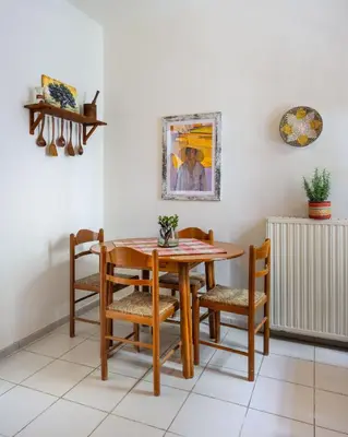 a dining room with a wooden table and chairs at Mira Seaside Residence in Kalívia Thorikoú