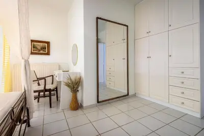 a white bathroom with a mirror and a table at Mira Seaside Residence in Kalívia Thorikoú