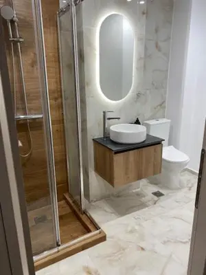 a bathroom with a sink and a shower with a mirror at Real City Suites Lekka in Athens