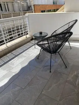 a patio with a table and a chair on a balcony at Real City Suites Lekka in Athens