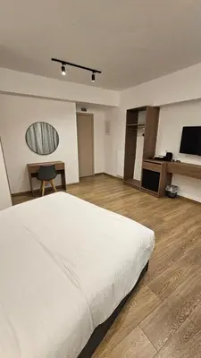 a bedroom with a large white bed and a desk at Real City Suites Lekka in Athens