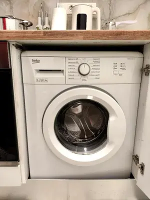a washing machine in a kitchen under a counter at Athenian Stay Chara's Apartment in Athens