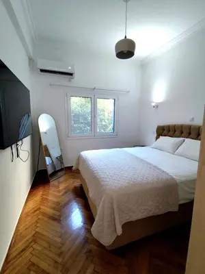 a white bedroom with a large bed and a window at Athenian Stay Chara's Apartment in Athens