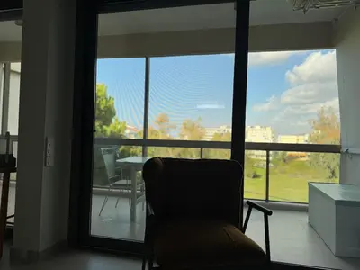 a chair in a room with a large window at Nomadic life-Elegant Apartment by Athens Riviera in Athens