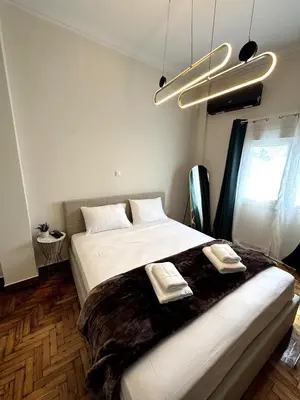 a bedroom with a large bed with two towels on it at Athenian Stay Chara's 2 Apartment in Athens