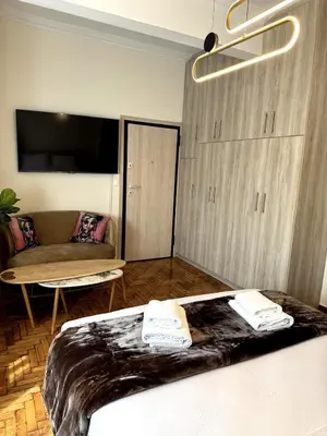 a bedroom with a bed and a couch and a tv at Athenian Stay Chara's 2 Apartment in Athens