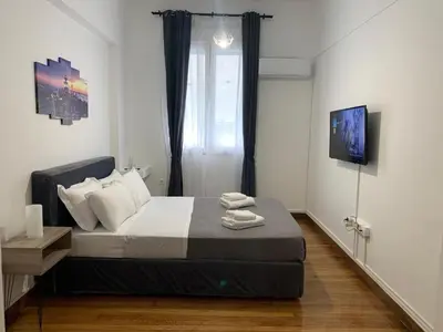 a bedroom with a bed and a television on a wall at Athenian Stay Kolonaki Apartment in Athens