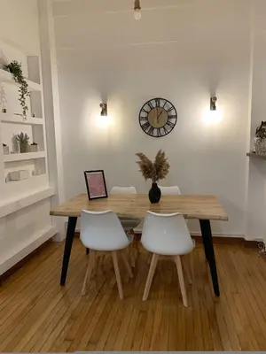a dining room table with chairs and a clock on the wall at Athenian Stay Kolonaki Apartment in Athens