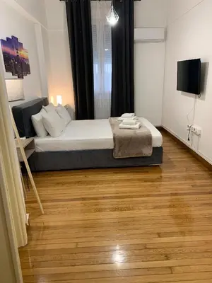 a bedroom with a bed and a wooden floor at Athenian Stay Kolonaki Apartment in Athens