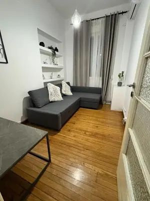 a living room with a couch and a wooden floor at Athenian Stay Kolonaki Apartment in Athens