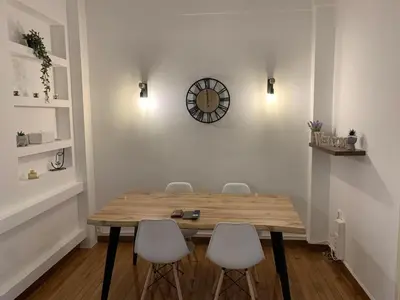 a dining room table with chairs and a clock on the wall at Athenian Stay Kolonaki Apartment in Athens