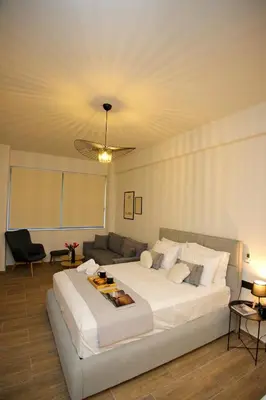 a bedroom with a large white bed and a couch at Blisséa in Piraeus
