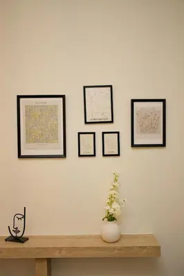 a wall with four framed pictures on a white wall at Blisséa in Piraeus