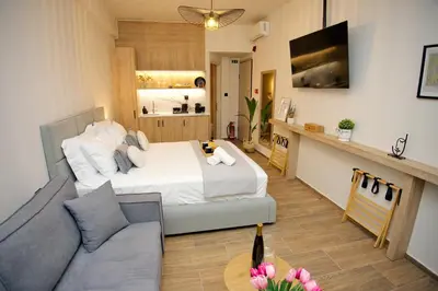 a bedroom with a bed and a living room with a couch at Blisséa in Piraeus