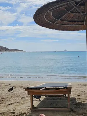a bench sitting on a beach with the ocean at Vouliagmeni Suite 1 by Anothr in Athens