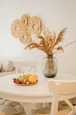 a table with a plate of fruit and a vase of flowers at Vouliagmeni Suite 1 by Anothr in Athens