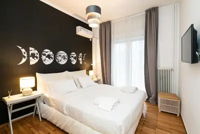 a bedroom with a white bed and a black wall at Athens Casa All Acropolis in Athens