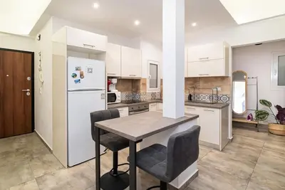 a kitchen with a table and chairs and a refrigerator at Athens Casa All Acropolis in Athens